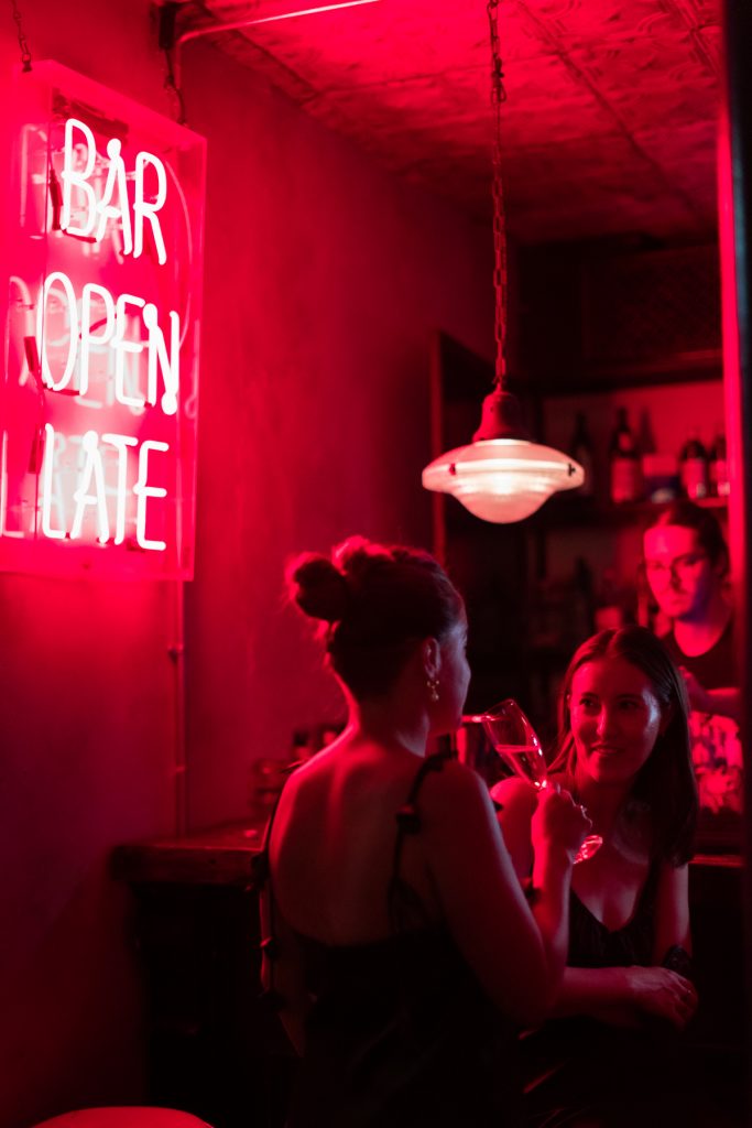 party photography in London pub. Neon sign saying Bar Open Late