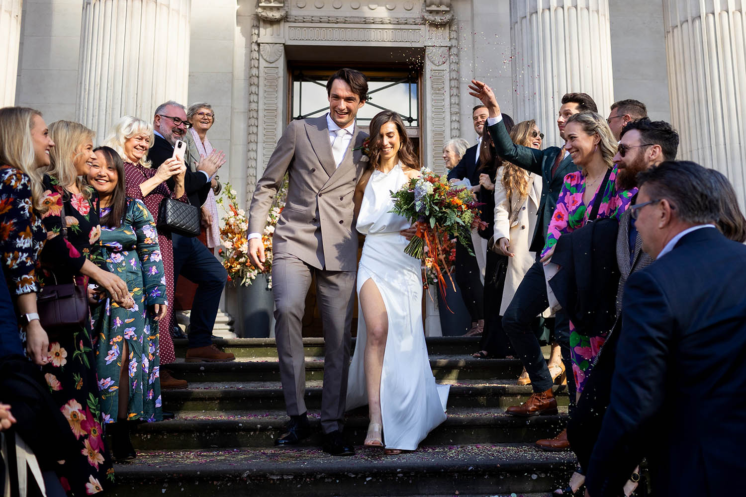 Couple emerging to confetti at Marylebone Old Town Hall.