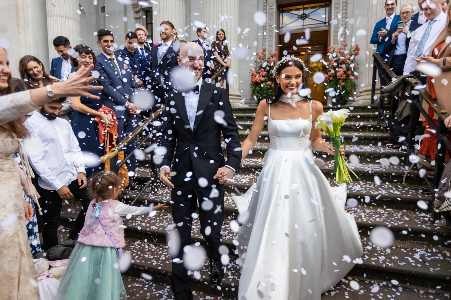 couple with confetti being thrown at them at Marylebone Old Town Hall